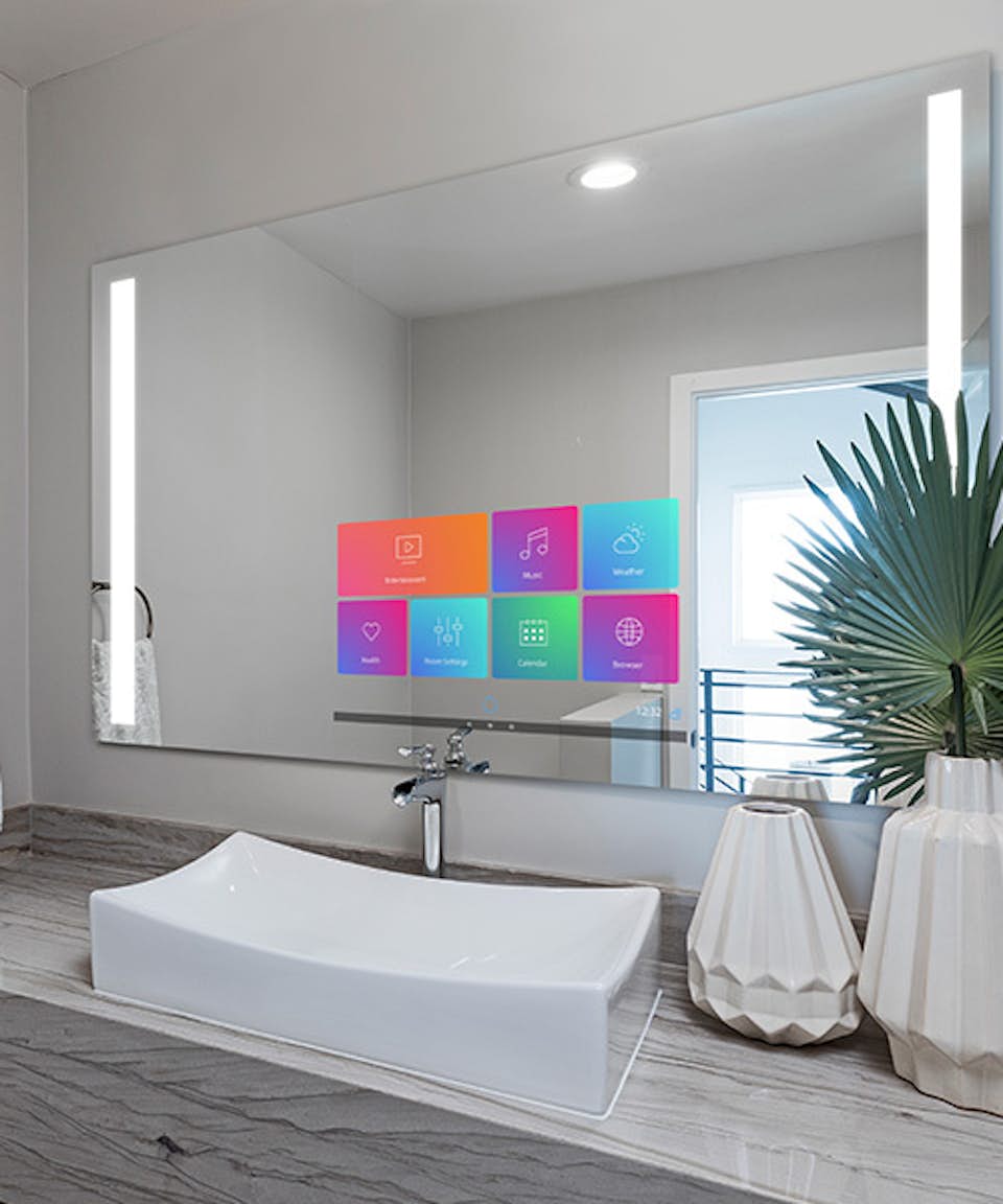 A smart mirror with apps displayed on its surface in the bathroom of a home.